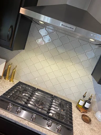 Spotless stainless steel gas cooktop and white tile backsplash cleaned by Sweeping Beauty Cleaning Omaha